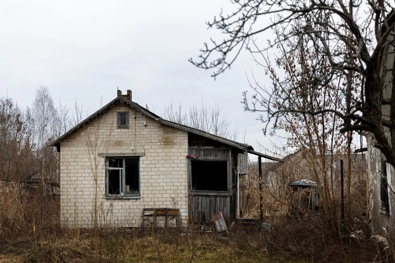 A view of an abandoned, decaying house amid nature.
