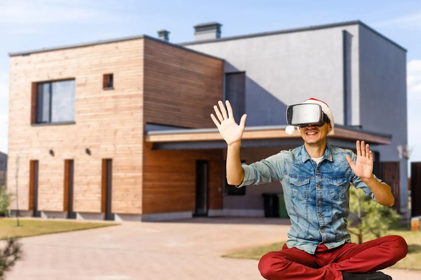Happy man wearing virtual glasses in front of a new house.